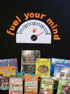 there are many children's books on the table with an orange and white sign that says fuel your mind