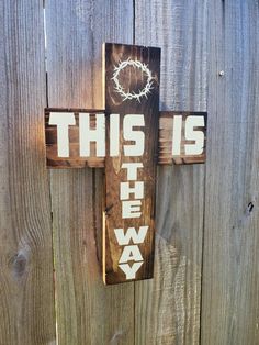 this is the way wooden cross with barbed wire hanging on it's back wall