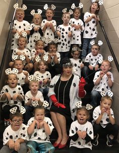 a group of children dressed in dalmatian costumes posing for a photo on an escalator