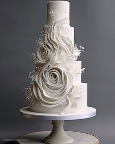 a three tiered white wedding cake with flowers on top