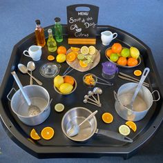 an assortment of cooking utensils are arranged on a black tray with menus