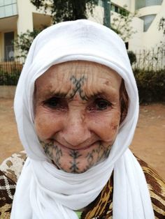 an old woman with tattoos on her face