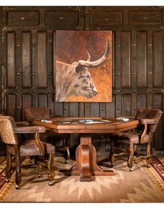 a table with chairs around it in front of a painting on the wall behind it