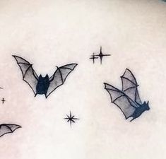 three bats flying in the sky with stars on their back side ribcage tattoos