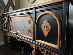 an ornate black and brown cabinet with gold hardware on the door knobs is shown in this photo