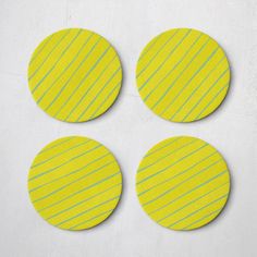 four yellow and green striped coasters on a white surface