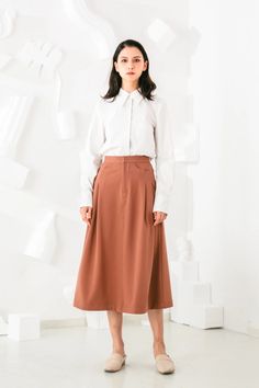 Invest in a timeless wardrobe staple with our chic Aurelie Midi Skirt. Its simple yet elegant silhouette is highlighted by elongating vertical pleats and a flattering A-line shape. Wear yours with feminine blouses and sleek outerwear. Vertical pleats create an elongated silhouette Elastic waist for all day ease and com Feminine Blouses, Timeless Wardrobe, Shape Wear, Timeless Wardrobe Staples, Silhouette Cut, High Waisted Skirt, Midi Skirt, Elastic Waist, A Line