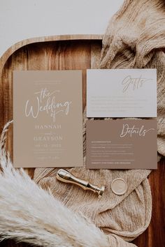 the wedding stationery is laid out on a wooden tray with fur and gold accents