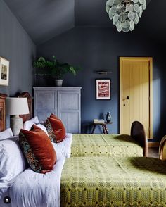 a bedroom with blue walls and green bedding