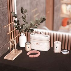 an assortment of items displayed on a table in front of a window, including a purse and bracelet