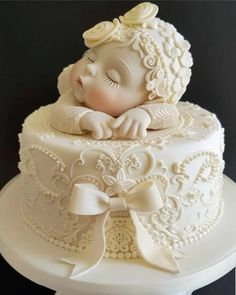 a white cake with a baby doll on top