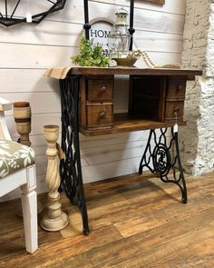 an old sewing table is sitting next to a chair