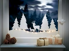 a window sill decorated with christmas lights and paper cut deers in the night sky