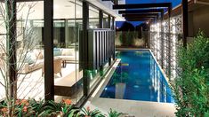 an indoor swimming pool in the middle of a house with glass doors on both sides