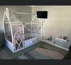 a child's bedroom with a pink and white play house bed in the corner