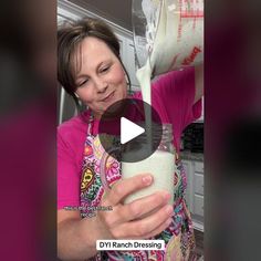 a woman pouring milk into a glass jar with the words diy ranch dressing on it