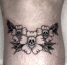 a woman's stomach with skulls and flowers on it