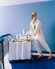 a man in white suit standing next to a table with food on it