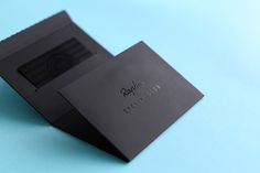 two black business cards sitting on top of each other