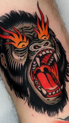 a man's arm with a tattoo on it that has an angry gorilla face and flames