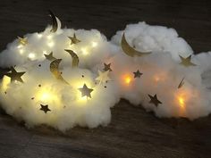 some white clouds with gold stars and moon lights in them on a wooden floor,