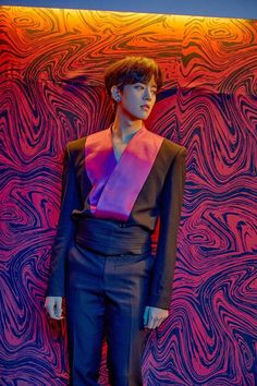 a mannequin wearing a suit and tie in front of a colorful background