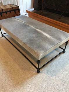 a concrete coffee table sitting on top of a carpeted floor next to a fireplace