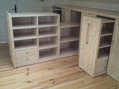 an empty room with wooden floors and shelves