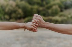 two people are holding hands with each other