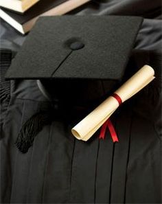 a graduation cap and gown sitting on top of a pile of books