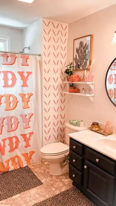 a bathroom decorated in pink and orange with the word baby on it's shower curtain