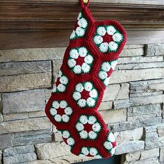 a crocheted christmas stocking hanging from a fireplace