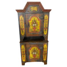 an old wooden cabinet with painted designs on the front and sides, against a white background