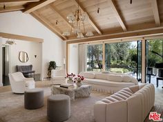 a living room filled with furniture and a piano in front of a large glass window