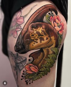 a woman's thigh with an animal and flowers tattoo design on her leg,