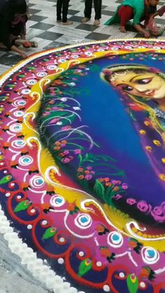 people are standing around a large cake with a painting on it