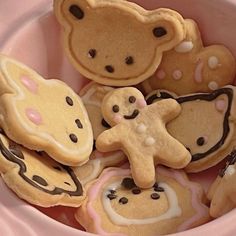 some cookies are in a pink bowl with teddy bears