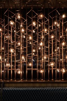 a metal structure with lots of lights hanging from it's sides and on the wall