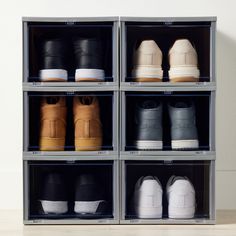 several pairs of shoes sitting on shelves in a storage unit with white walls and wood flooring