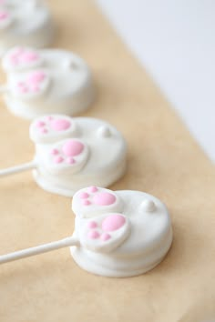 the cake pops are decorated with white frosting and pink bunny's ears on them