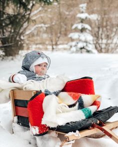 a small child sitting on top of a sled in the snow