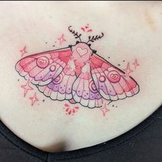 a woman's chest with a pink butterfly tattoo on it