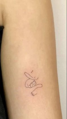 a woman's arm with a small tattoo of a cat on the left side