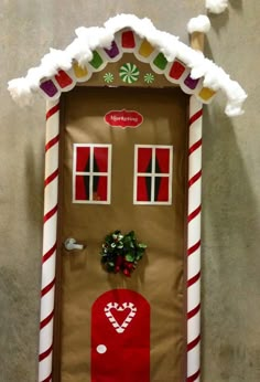 a door decorated to look like a gingerbread house with candy canes on it