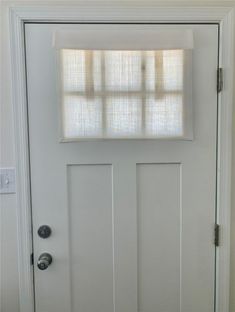 a white door with a window and blinds on it