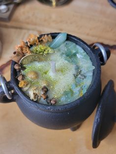 a pot filled with lots of green stuff on top of a table