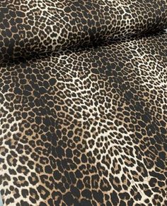 an animal print fabric is shown in brown and black colors, with white spots on it