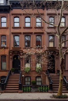 an apartment building with many windows and steps leading up to the front door, on a city street