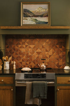 a stove top oven sitting inside of a kitchen next to a painting on the wall