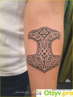 an image of a tattoo on someone's arm with an ax in the middle